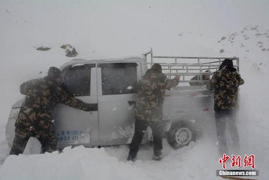 12日，新疆阿勒泰邊防官兵在救援被困車輛。（圖片來源：中新網(wǎng)）