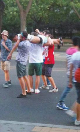 四名外籍男子一同扛起醉漢拍照。