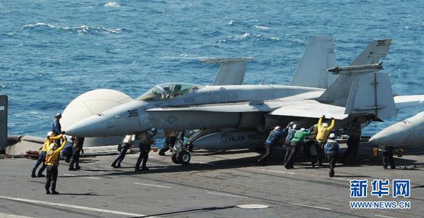美軍開始對伊拉克極端組織發動空襲這張美國海軍8月8日提供的照片顯示，在海灣地區執行任務的“喬治·H·W·布什”號航空母艦上，地勤人員指揮一架F A-18C大黃蜂戰斗機。新華社發