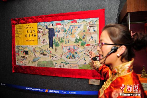 。圖為工作人員介紹1954年十世班禪額爾德尼敬獻(xiàn)給中央政府的唐卡。