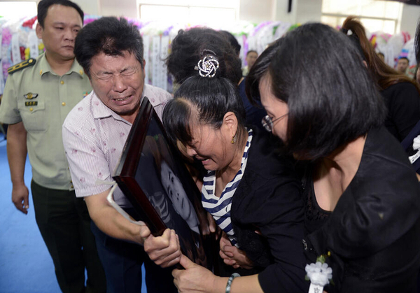圖為追悼會完畢時，謝樵的父母親緊緊抱住遺像。