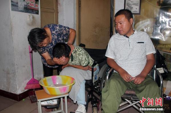 為了給52歲的母親減少負(fù)擔(dān)，兄弟二人經(jīng)常半個(gè)多月都不洗漱。見(jiàn)記者前來(lái)兄弟二人才特意請(qǐng)母親給自己洗把臉。 馬義恒 攝