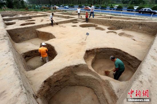 圖為考古工作人員發掘工地清理灰坑 圖為考古工作人員發掘工地清理灰坑