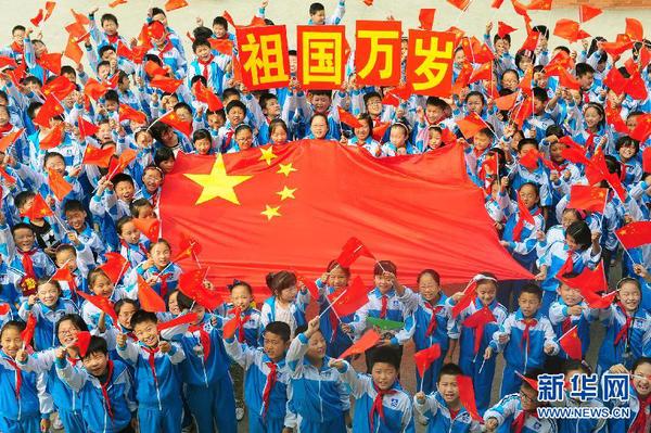 9月26日，安徽省阜陽市北城小學分校的學生與國旗合影。新華社發(fā)（王彪 攝）