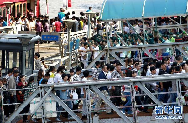 10月1日，游客在上海外灘排隊乘坐觀光游輪。當日是國慶長假第一天，全國各地旅游景點游人如織。 新華社記者 丁汀 攝