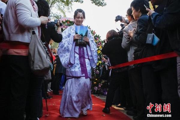 10月16日，身著漢服的學(xué)生走過“成人門”和紅地毯。