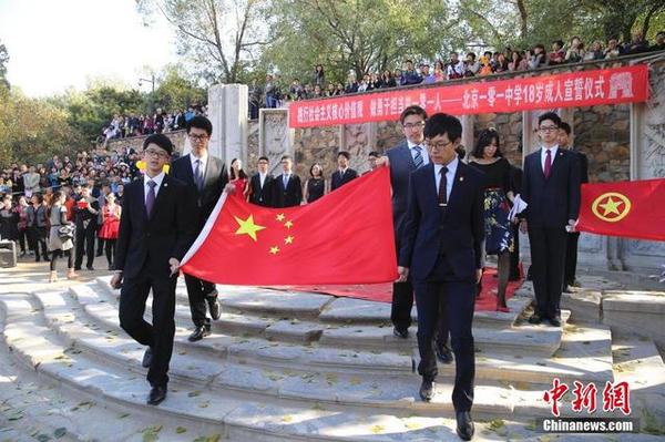 10月16日，學(xué)生們舉起老師們贈送的國旗。