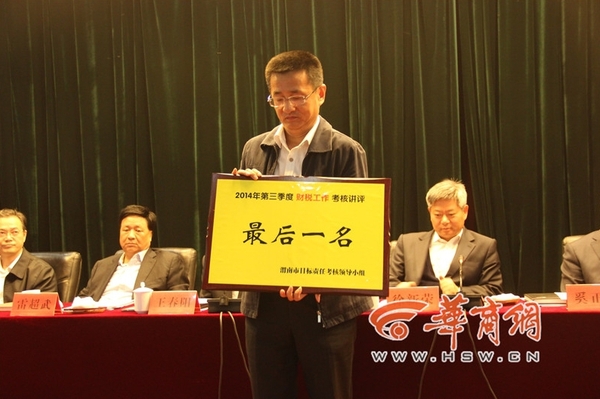 10月23日，渭南市召開的2014年縣區(qū)的政績考核會議上，有6個縣市區(qū)因為“較差”也上臺“領(lǐng)獎”，他們領(lǐng)到的是一個“最后一名”。圖為韓城市因為在財稅工作方面考核排名較后，獲取了一個黃牌。
