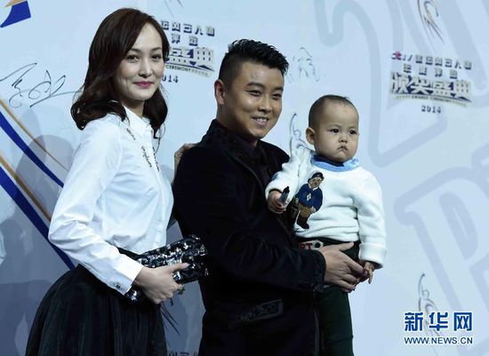 2月1日，前乒乓球國手王皓（中）抱著兒子小樂天與妻子閆博雅在頒獎典禮紅毯儀式上合影。當日，“2014CCTV體壇風云人物年度評選”頒獎典禮在京舉行。 新華社記者公磊攝