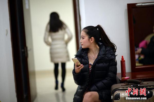 　　換裝后，舉牌女郎在化裝室休息。中新社發 稻草 攝 圖片來源：CNSPHOTO