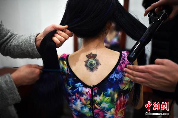 　一位舉牌女郎后背上的紋身。中新社發 稻草 攝 圖片來源：CNSPHOTO
