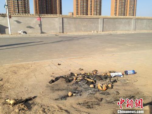 親人在何建華遇害處燃燒的紙錢和祭品。 王天譯 攝