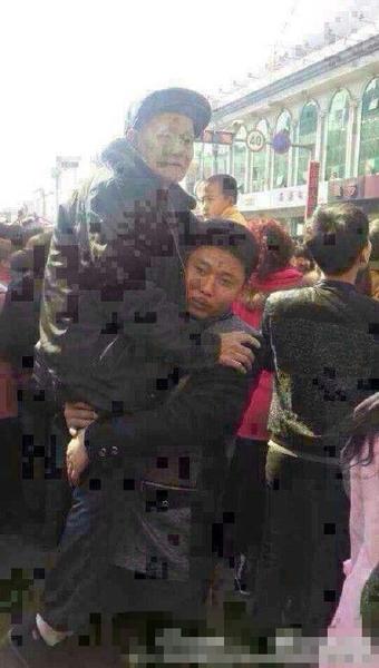 被抱起的老者，年紀大約70多歲，手持拐杖，穿戴一新。