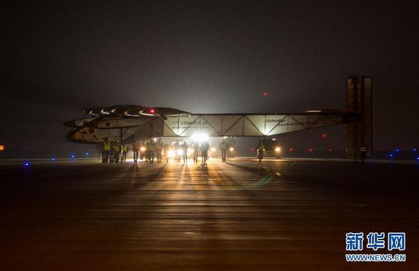 31日凌晨，工作人員在停機坪上推著太陽能飛機向臨時搭建的專用機庫前行。