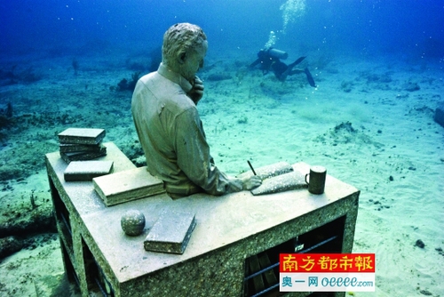 游客背著呼吸器深入水中觀看雕塑。