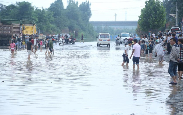 道路積水嚴(yán)重村民水中撈車牌賣錢-一個要價100元2