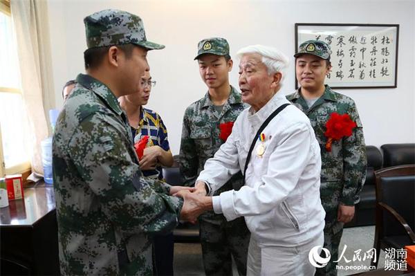 抗戰老兵方耀寰握住入伍新兵的手，囑咐他們要收好香港地區的繁榮與和平，在軍隊努力學習，為國貢獻。 胡丹  攝