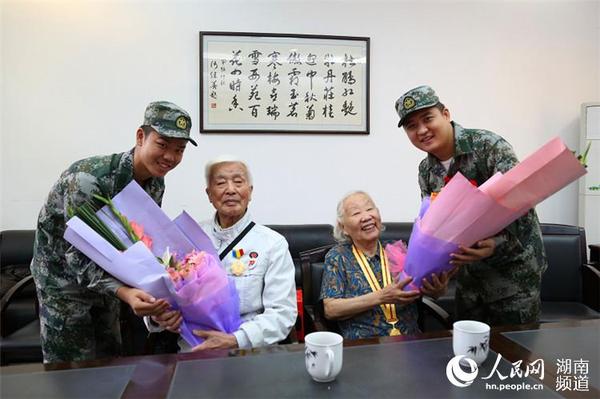 岳麓區即將去往駐港部隊的新兵代表為抗戰老兵方耀寰、惲順芳送上鮮花與月餅，祝福老人節日快樂。 胡丹 攝