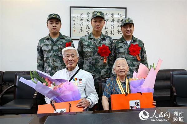 9月8日，岳麓區即將去往駐港部隊的新兵代表為抗戰老兵方耀寰、惲順芳送上鮮花與月餅，祝福老人節日快樂。 胡丹 攝