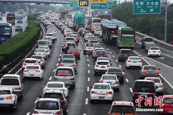 10月1日，江蘇蘇州，國慶長假高速公路免費通行第一天，沿江高速江蘇省太倉主線收費站附近出現數百米的車流長龍，從上海方向駛出的大量車輛緩慢通行經過沿江高速江蘇太倉段。計海新 攝 圖片來源 CFP視覺中國