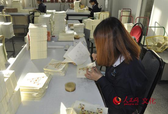 檢票員正在仔細檢查每一張郵票。(人民網 王鶴瑾 攝)