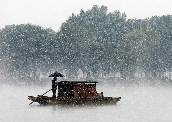 12月5日，杭州降下2015年入冬第一場雪。沒有一點點防備，杭州的初雪就洋洋灑灑地飄落了，雪越來越大，氣溫也驟降，西湖的水面上飄起層層白霧，與雪花攪在一起，如夢似幻。林云龍 視覺中國