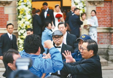　李登輝孫女李坤儀（后排中）結婚，一名藍衣男子突然丟紙鬧場，李登輝和孫女面露驚恐。來源：臺灣《聯合報》
