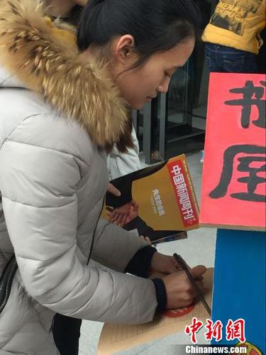 　兩名大學生從“鳥巢書屋”取走書籍后自覺進行登記。　韓章云　攝