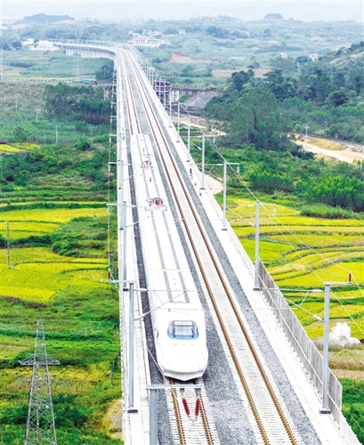 　12月3日，一輛試運行的“和諧號”列車從廣西南寧市隆安縣境內的一座高架橋經(jīng)過。韋萬忠攝（新華社發(fā)）