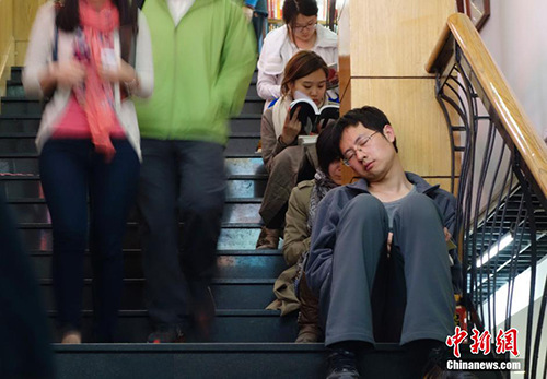  資料圖：2014年4月10日，已近午夜，位于北京美術(shù)館東街的三聯(lián)韜奮書店內(nèi)燈火通明，顧客絡(luò)繹不絕，書店還為顧客提供了桌椅臺燈方便閱讀。這家已有20余年歷史的書店成為北京嘗試24小時開放的書店之一。<a target='_blank' href='http://www.chinanews.com/'>中新社</a>發(fā) 杜洋 攝