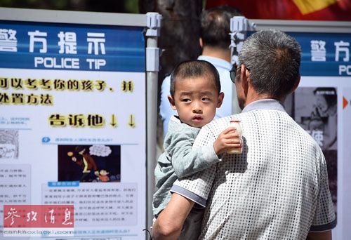 資料圖：2015年6月1日，市民在觀看長春市公安局發布的兒童安全常識。當日，吉林省長春市兒童公園舉行“關愛兒童，反對拐賣”主題大型宣傳活動。新華社記者