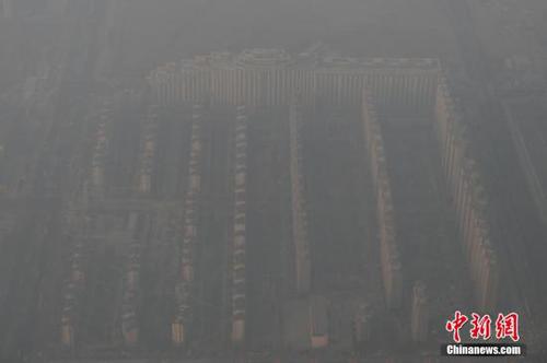 資料圖：2015年12月21日，北京上空航拍空氣重污染，地面建筑若隱若現。12月18日，北京再次發布紅色預警，12月19日7時至12月22日24時啟動空氣重污染紅色預警措施。實施機動車單雙號行駛、建議中小學幼兒園停課等措施。 <a target='_blank' href='http://www.chinanews.com/'>中新社</a>記者 廖攀 攝
