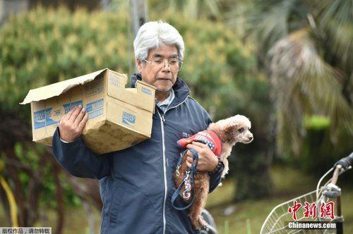 當地時間4月17日，一位老人抱著自己的愛犬領救災物資。