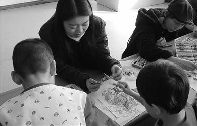翟月正在指導自閉癥兒童涂畫她設計的中國版“秘密花園”