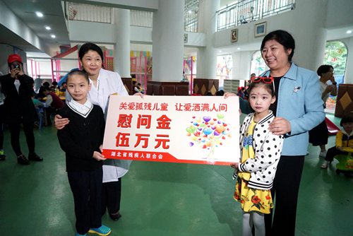 圖為省殘工委副主任、省殘聯黨組書記、理事長陶慧芬委武漢市兒童福利院孤殘兒童送去慰問金