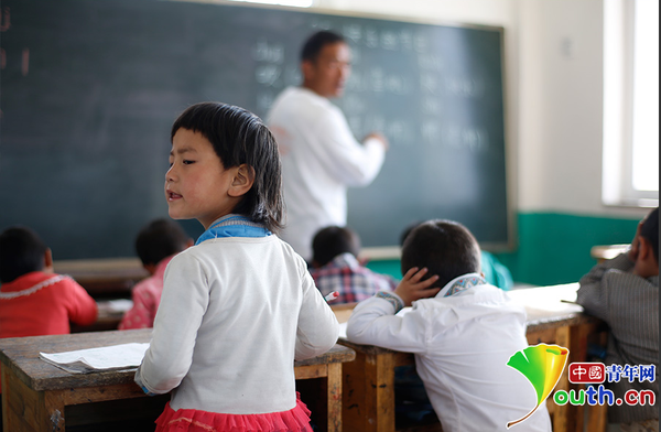　6歲的藏族女孩黃娜姆措站著聽黃老師講課。黃三英的課堂上氛圍很活躍，孩子們跟黃老師一起，又學習、又玩耍。中國青年網記者 張炎良 攝