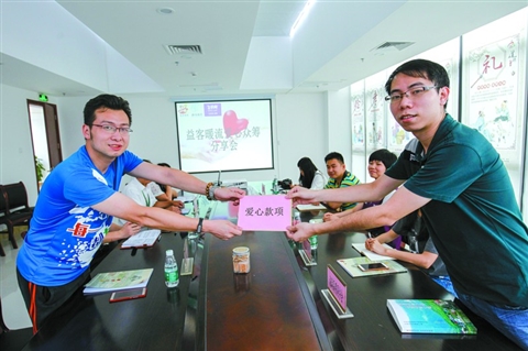 　　5月25日，益客暖流愛心眾籌分享會在高明好人工作室開啟。愛心商家代表(右)向公益聯(lián)盟單位代表獻上愛心款項。