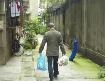 成都某中學(xué)外的小區(qū)內(nèi)，一家長用中午空閑時間給住在這里的孩子買菜做飯。