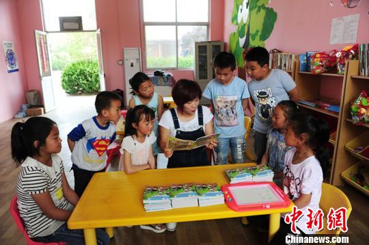 據(jù)了解，每個“留守兒童之家”專配一名兒童福利主任，負責教學設施管理和留守兒童的福利救助。圖為兒童福利主任正在給孩子們傳授知識?！匦焱?攝