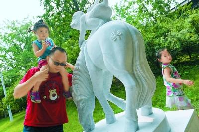 排隊購買“猴年馬月”特色郵品后，人們喜歡摸一摸“馬上封侯”的雕塑，為家人祚福。