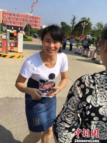 王女士將兒子身份證送到考點(diǎn)門口交給送考老師。　姚振男　攝