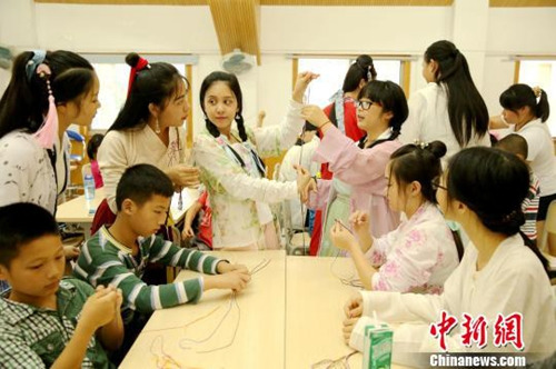 資料圖：桂林漢服愛好者舉辦“端午雅集”活動，現場教學編織五彩繩。裴蕾 攝