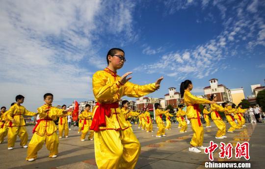 身著黃色統一古式服裝的少年打太極拳。　傅建斌　攝