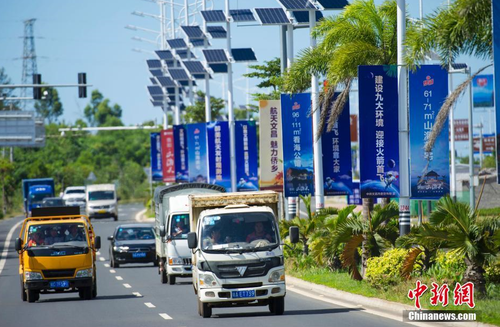 6月24日，海南省文昌市旅游大道的太陽(yáng)能路燈桿上懸掛著火箭“首發(fā)”宣傳廣告。長(zhǎng)征七號(hào)運(yùn)載火箭發(fā)射日期臨近，中國(guó)首個(gè)濱海航天發(fā)射中心——文昌航天發(fā)射場(chǎng)所在地海南省文昌市龍樓鎮(zhèn)將迎來(lái)“首發(fā)”，中國(guó)的“卡納維拉爾角”正揭開神秘面紗。中新社記者 駱云飛 攝