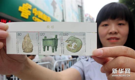 7月13日，一名集郵愛好者在江蘇蘇州郵政局展示剛購買的《殷墟》特種郵票。