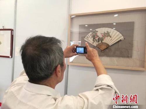 圖為中國(guó)書畫家協(xié)會(huì)理事、臺(tái)灣中華大漢書藝協(xié)會(huì)特聘書畫大師翟因欽在拍照?！√K路程 攝