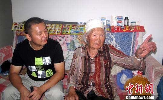 馮大媽向記者介紹何生強照顧社區(qū)老人的情況。　楊東 攝