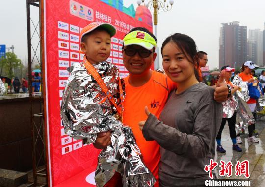 來(lái)自廣州的李強(qiáng)夫婦用兒童車，載著4歲的兒子，一家三口完成了在桂林舉行的半程馬拉松比賽。　歐惠蘭 攝