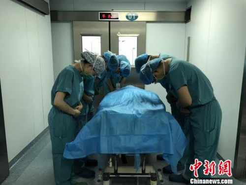 器官摘除手術結束后，醫護人員向楊先松的遺體默哀致敬?！±蠲?攝