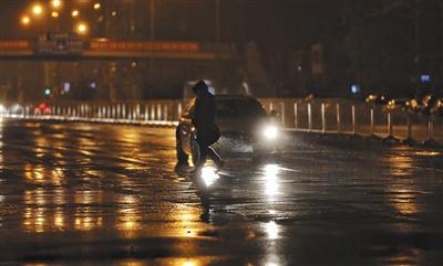 昨日，大望路，行人正在冒雨過(guò)人行道。 新京報(bào)記者 王飛 攝